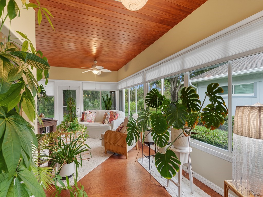 Sunroom with full-height windows, wood-paneled ceiling, and a ceiling fan