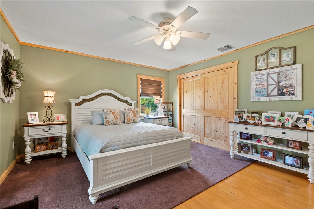 Ceiling fan with integrated lighting, wood-finish flooring, accent wall trim, sliding wood-panel closet doors, and recessed lighting