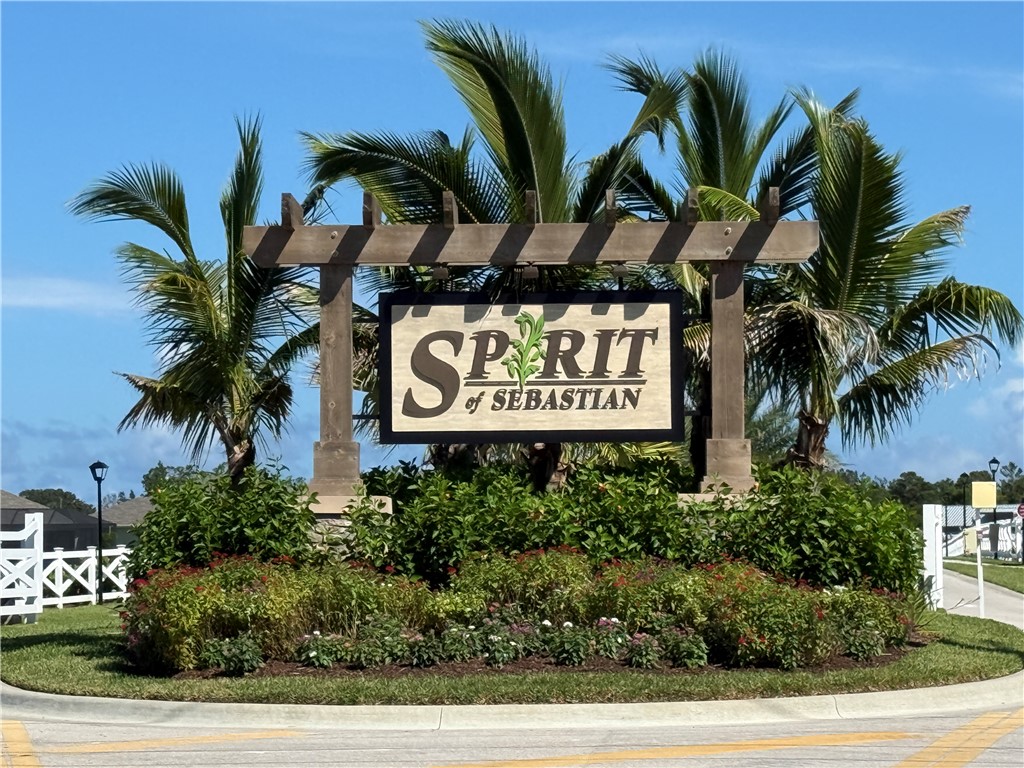 Community entrance signage featuring a wooden pergola and established landscaping