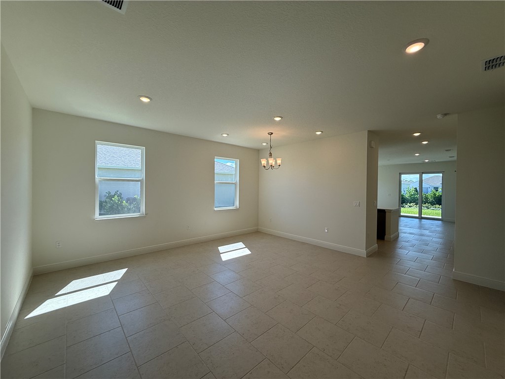 Recessed lighting, tile flooring, and a chandelier fixture
