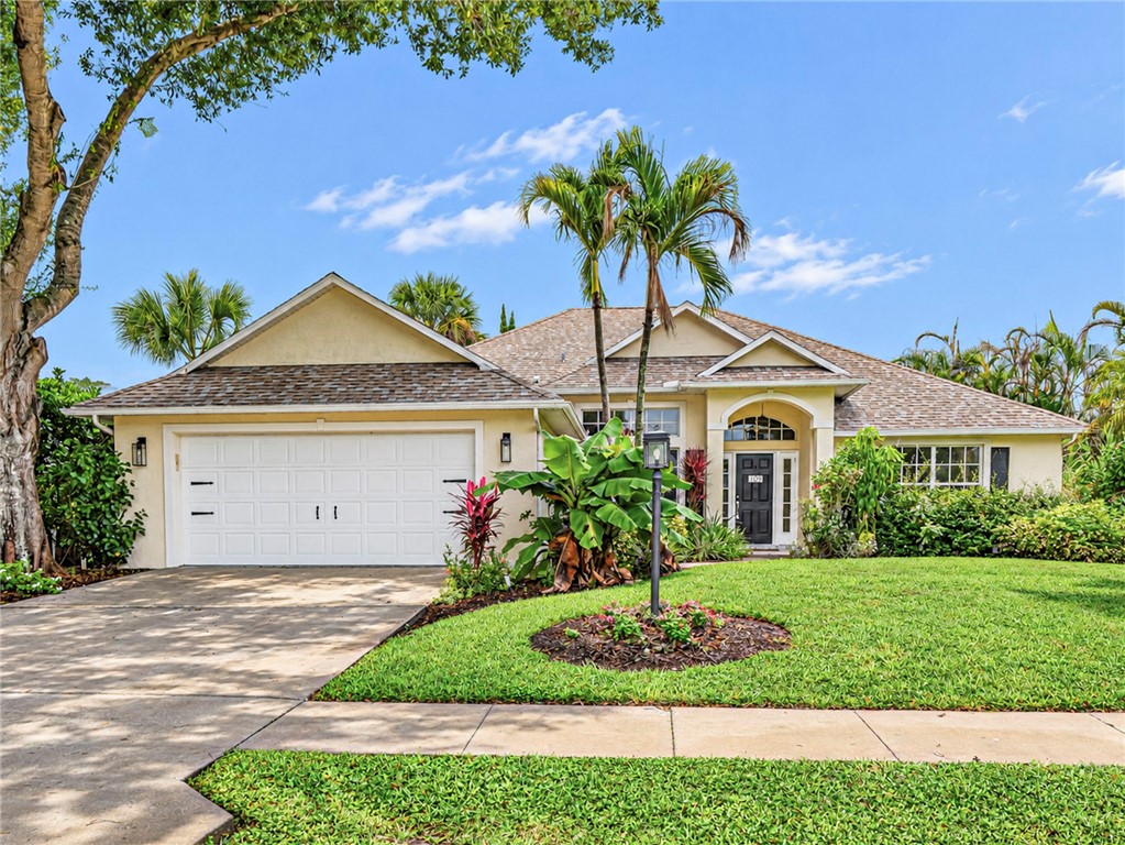 Stucco exterior with a hip roof, arched entry, and a two-car garage