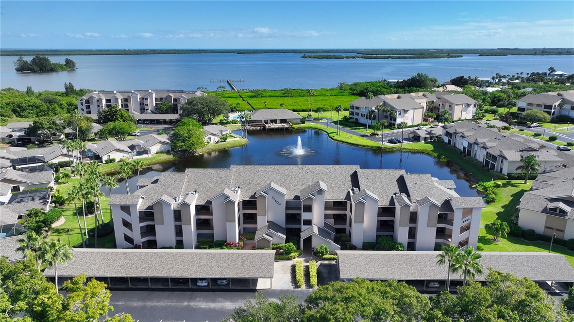 Multi-story condominium complex featuring a central courtyard with a pond and fountain