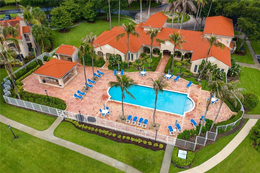 Expansive outdoor pool area featuring a rectangular pool, paver deck, and surrounding lush landscaping