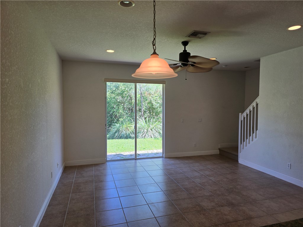 Tiled flooring complemented by recessed lighting and a ceiling fan