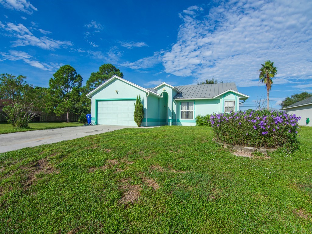 Lush green lawn with mature landscaping and flowering shrubs