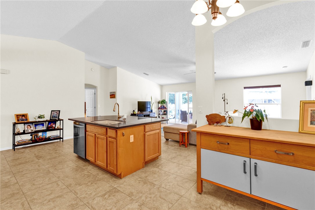 Kitchen island with wood-finish cabinetry and dark countertop