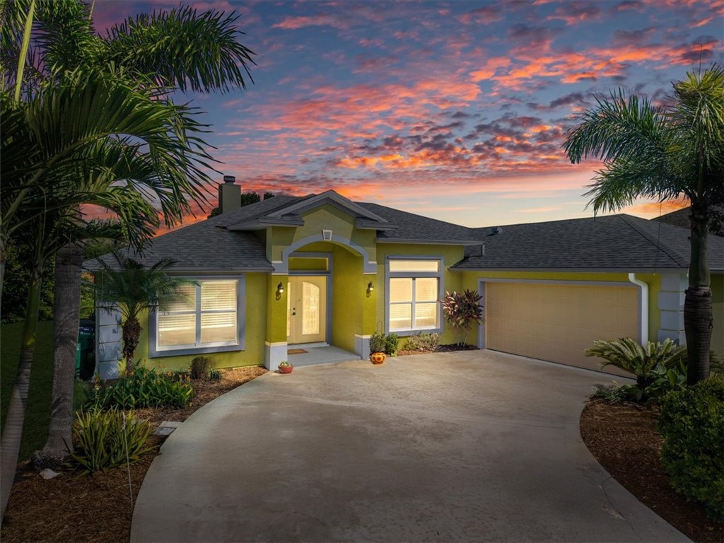 Single-story residence featuring a two-car garage, concrete driveway, and established landscaping