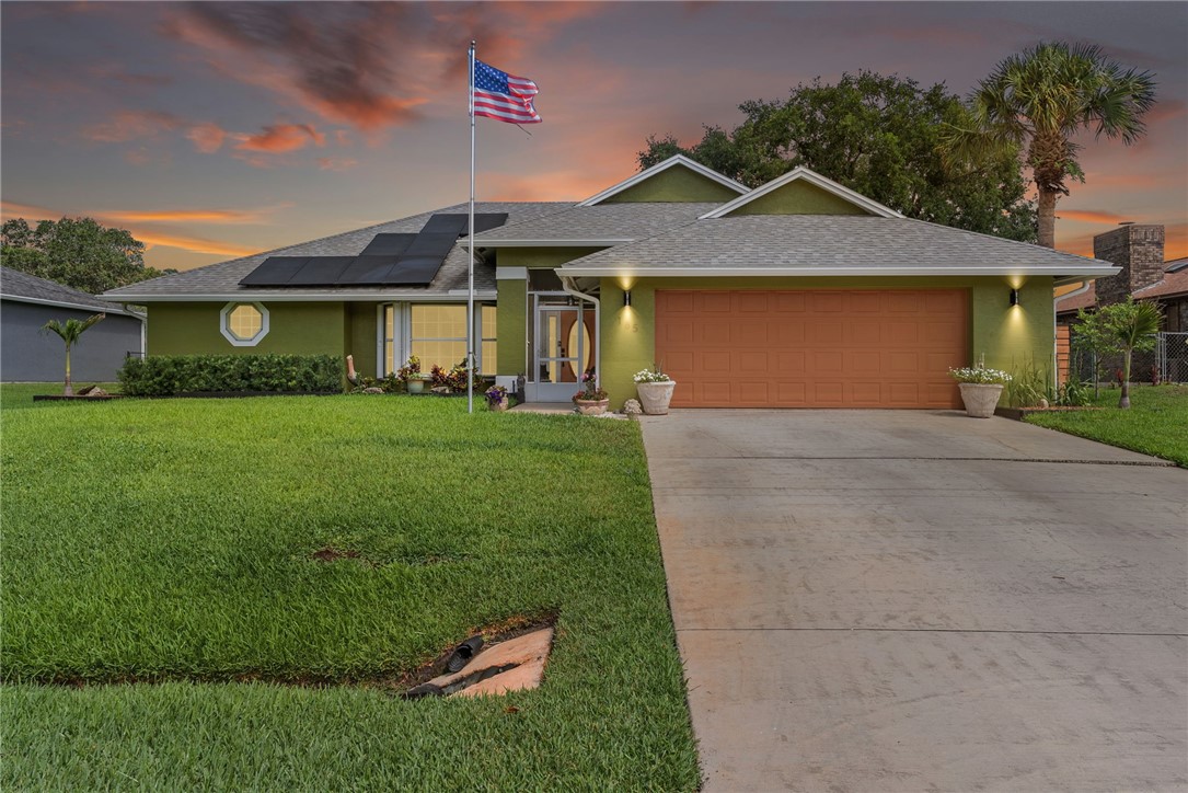 Single-story residence featuring a two-car garage, solar panel installation, and a round octagonal window