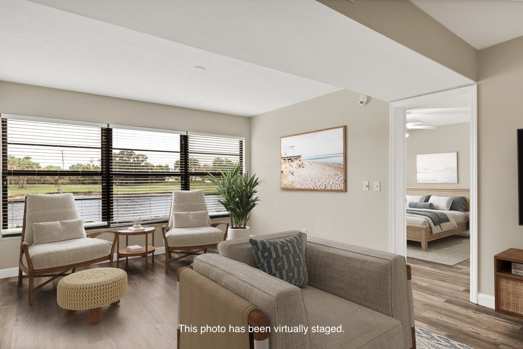 Expansive window wall with horizontal blinds, wood-finish flooring, recessed ceiling lighting, and a neutral wall palette