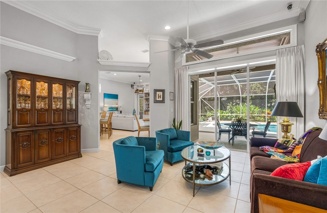 Living room with crown moldings, transom window, triple stack sliders