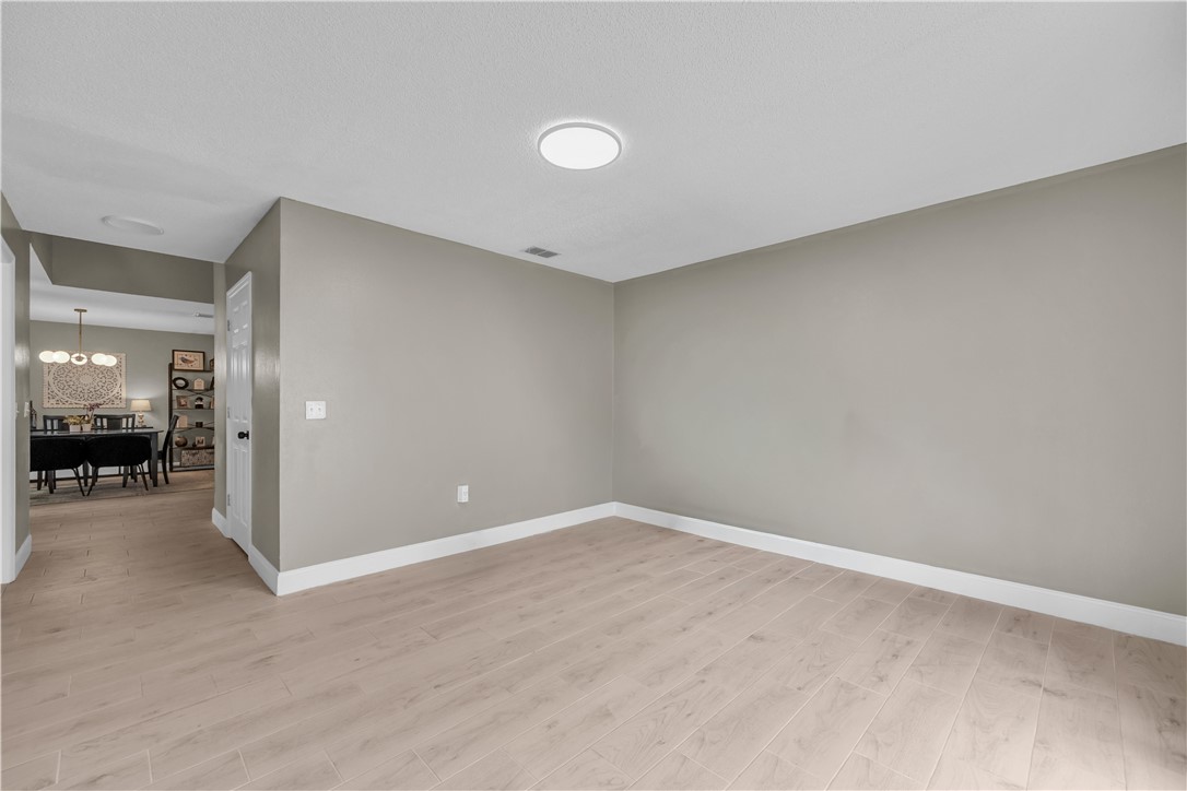 Neutral-toned interior featuring wood-finish flooring, recessed lighting, and a crisp white door frame