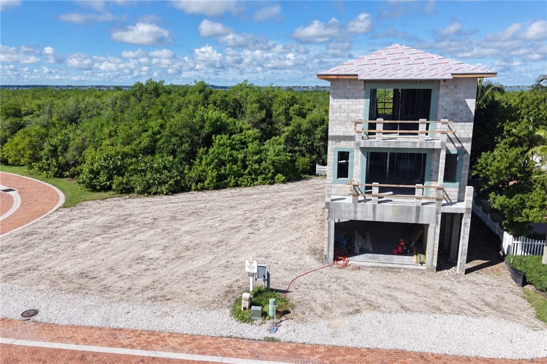 Multi-level construction featuring two upper balconies, a ground-level garage opening, and a partial roof installation