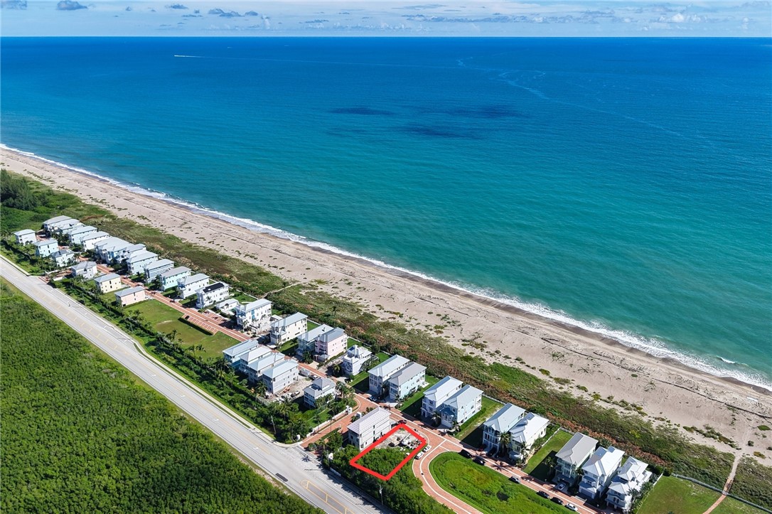 Beachfront property with direct beach access, coastal landscaping, and proximity to paved roadways