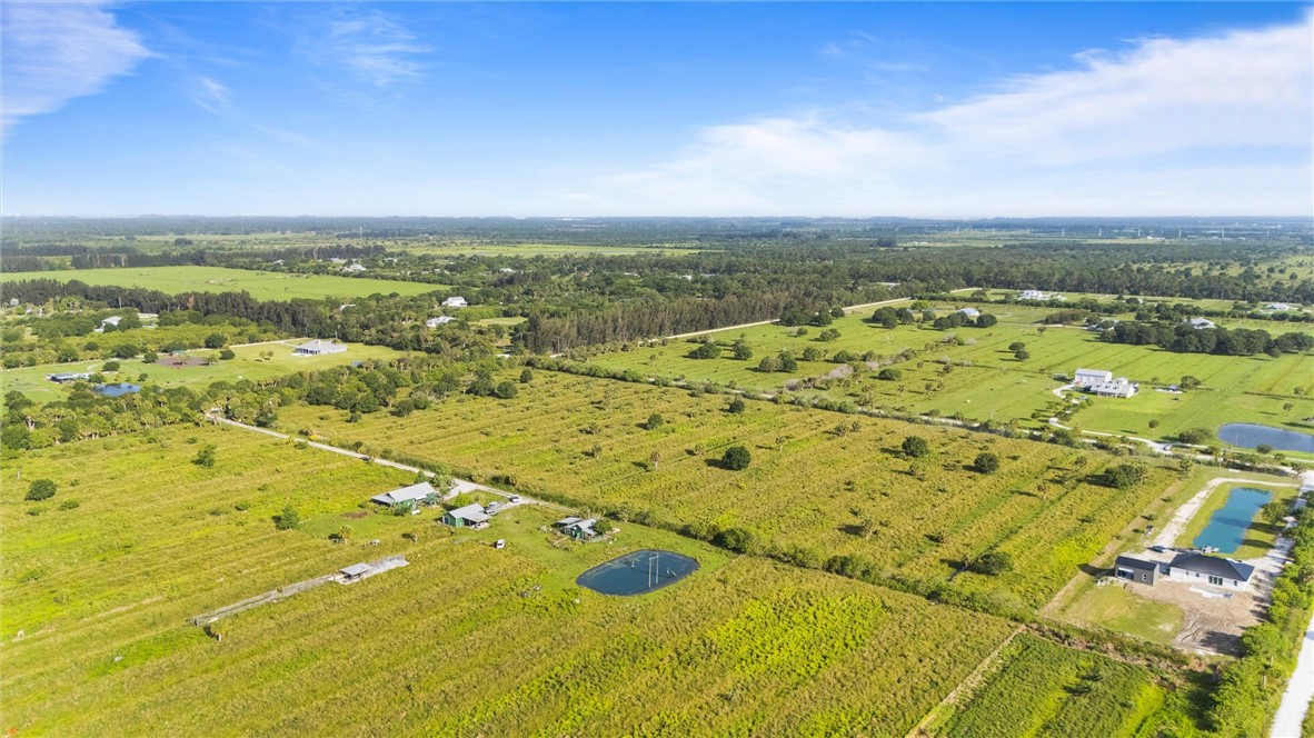 Expansive acreage featuring multiple fields, wooded areas, and a visible pond