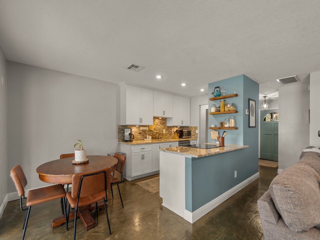 Kitchen featuring white cabinetry, stone-finish countertops, tile backsplash, built-in recessed lighting, and wall-mounted shelving