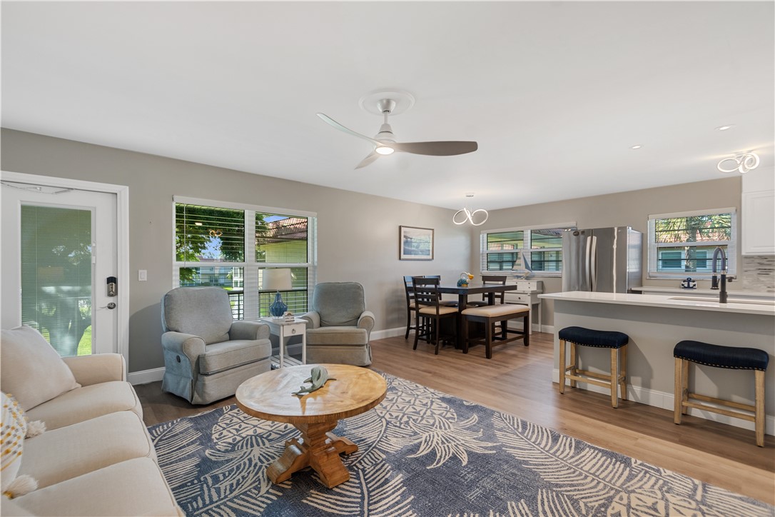 Open-concept interior featuring wood-finish flooring, a kitchen peninsula with a countertop, recessed lighting, and a ceiling fan