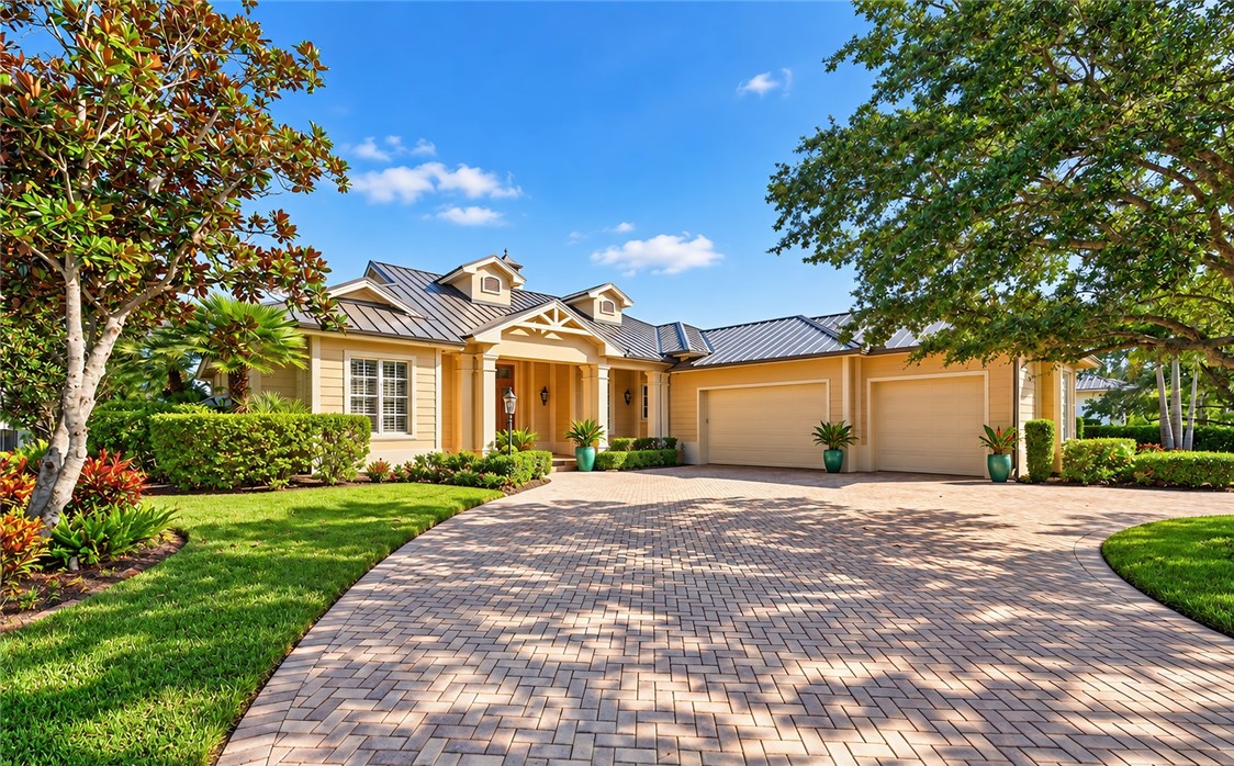 Single-story featuring a metal roof, herringbone-patterned paver driveway, covered entryway, and three-car garage
