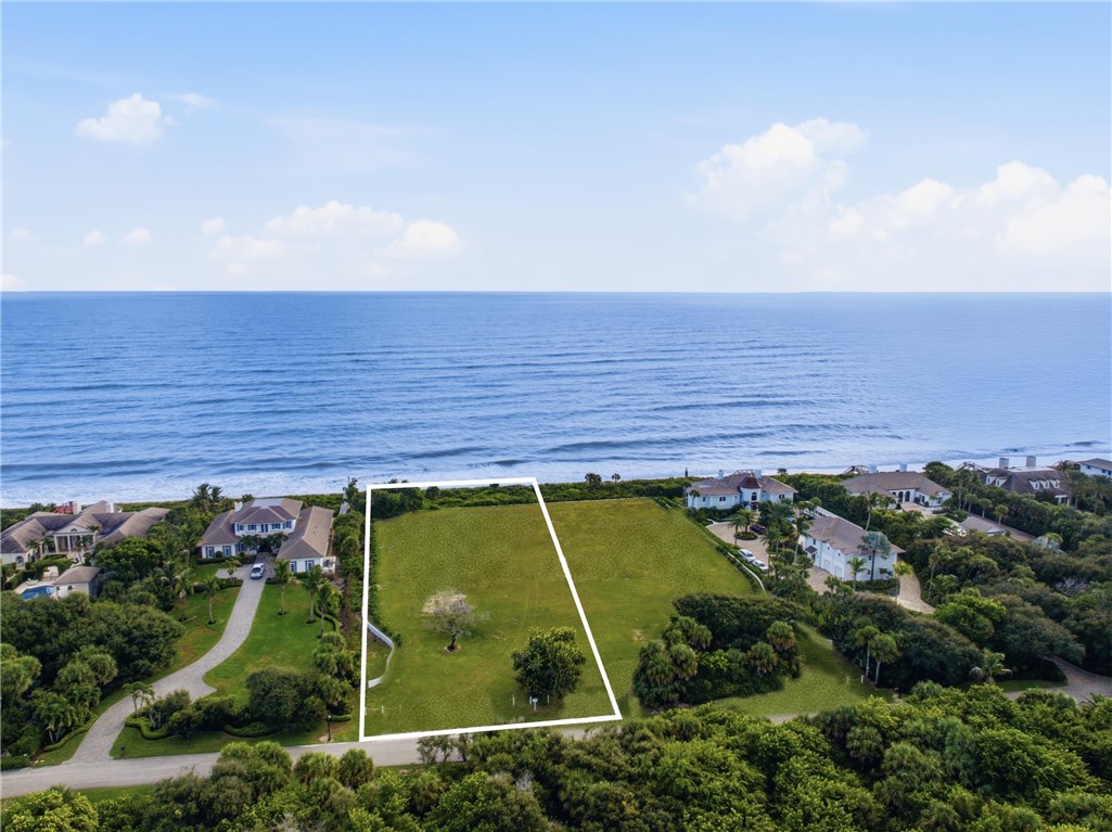 Direct oceanfront vacant land featuring expansive coastal acreage, mature trees, and immediate shoreline access