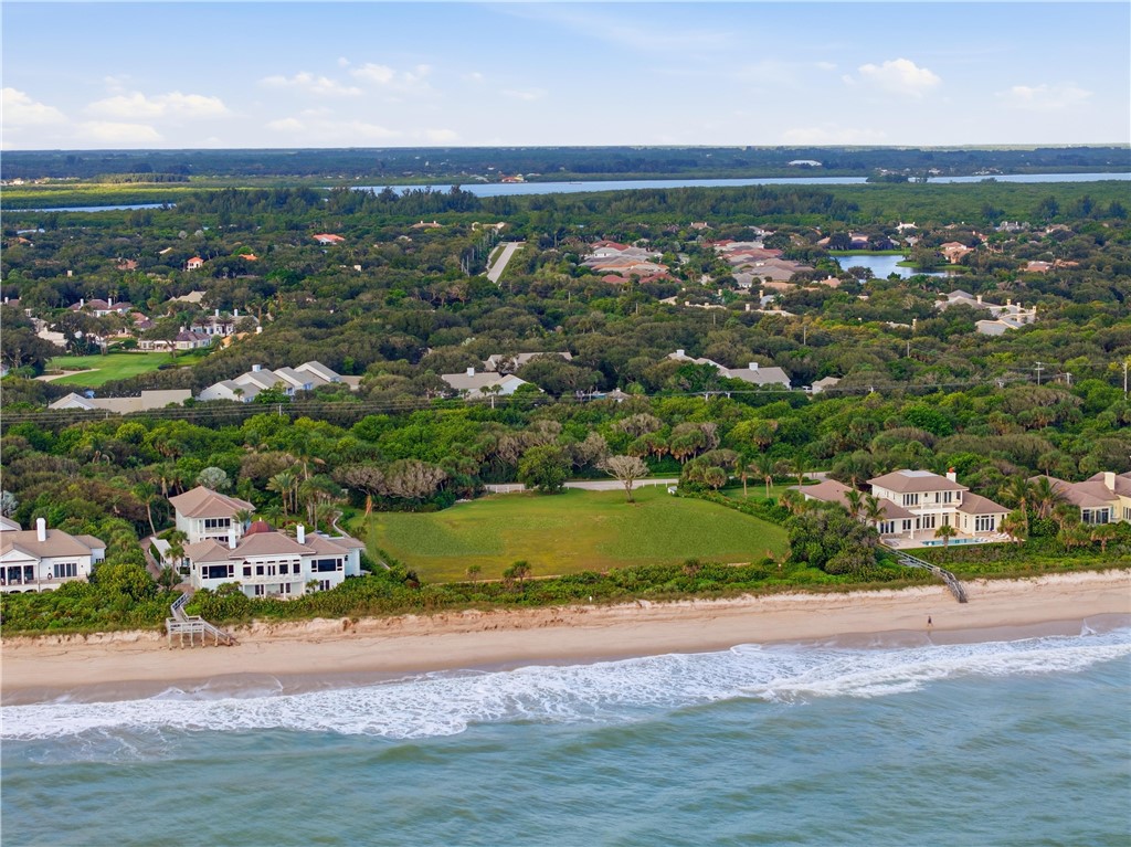 Coastal property featuring direct oceanfront access, expansive sandy shoreline, and proximity to established wooded acreage