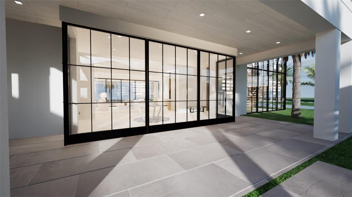 Covered patio featuring large-format stone pavers, black metal-framed glass panel sliding doors, and recessed ceiling lighting