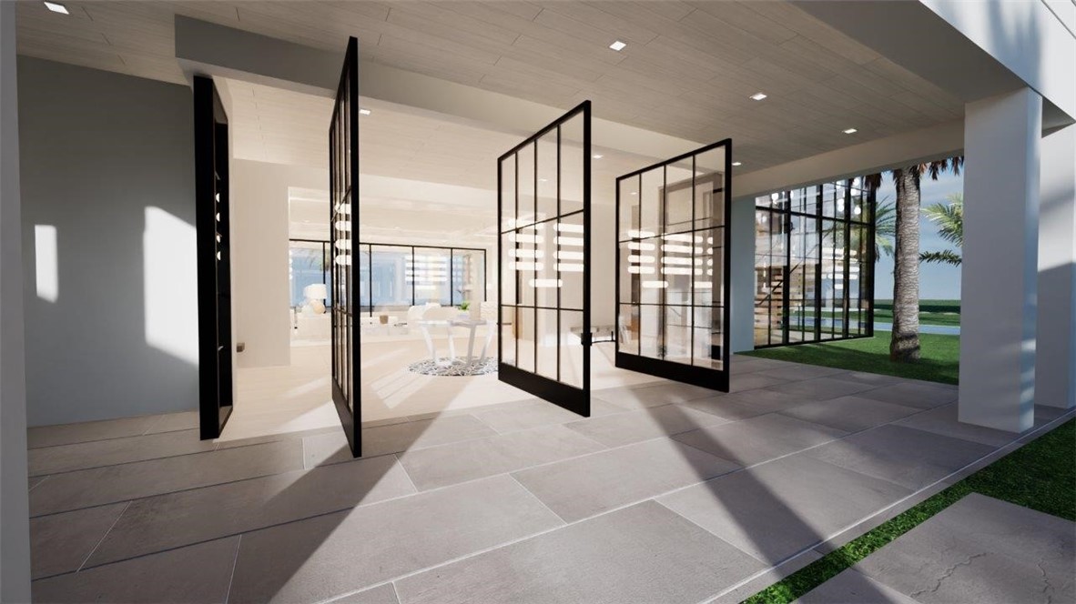 Covered stone-paved patio featuring black-framed pivot glass doors, recessed lighting, and a light-toned ceiling finish