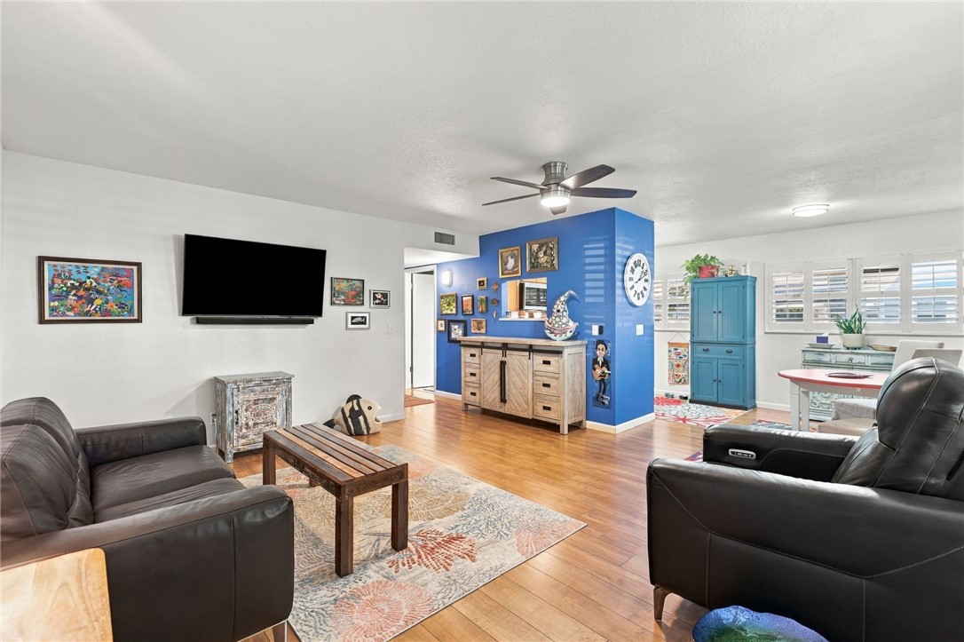 Open-concept living space featuring wood-finish flooring, recessed lighting, and a ceiling fan