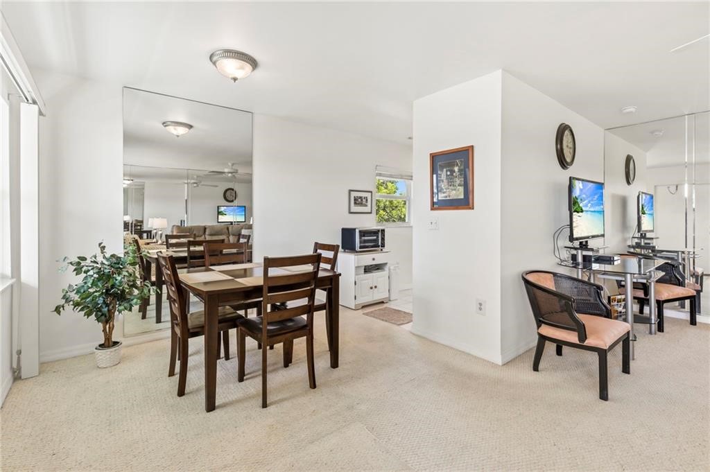 Interior space featuring wall-to-wall mirrored panels, flush-mount ceiling lighting, and neutral carpeting