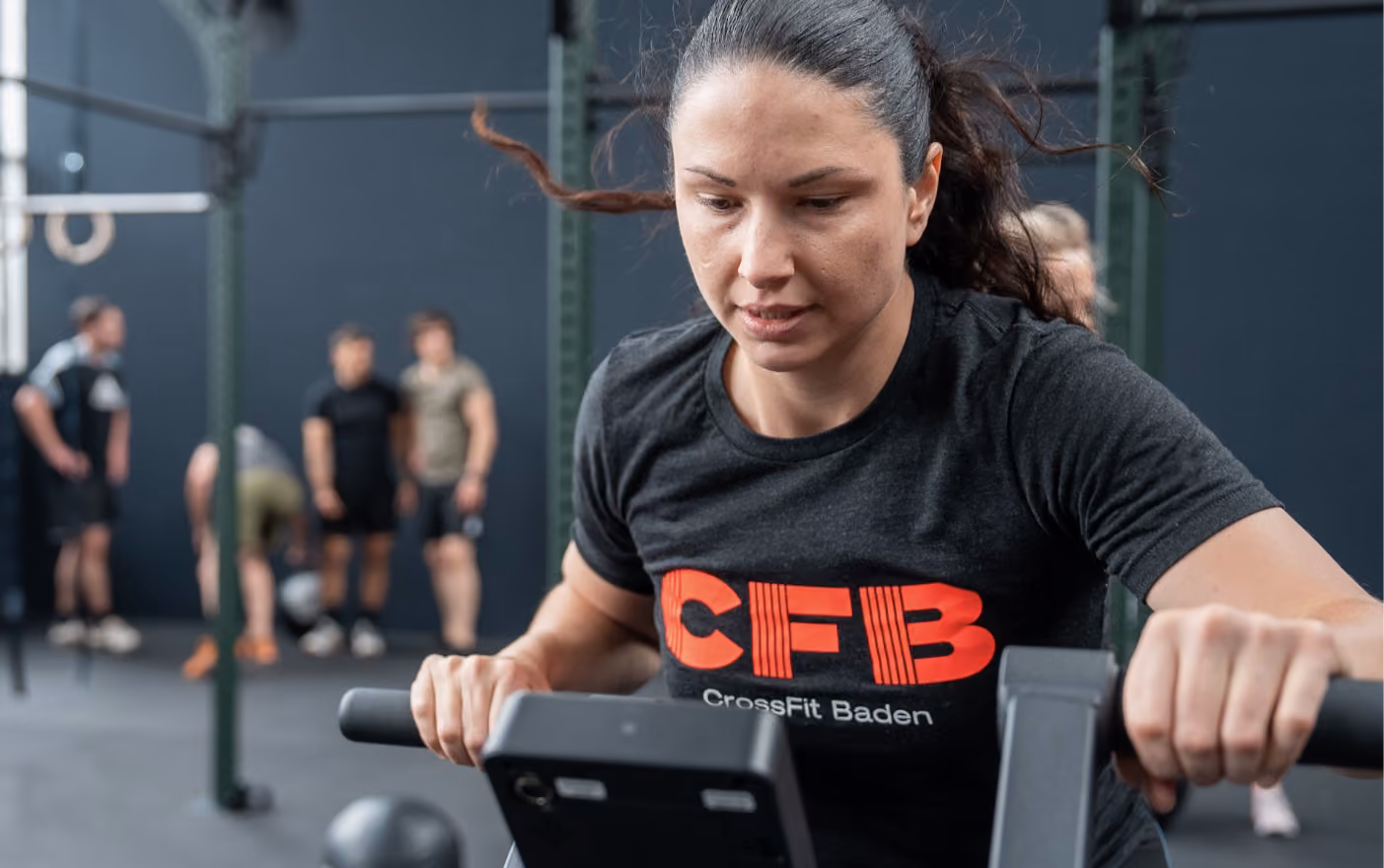 Frau beim intensiven Training auf dem Rudergerät
