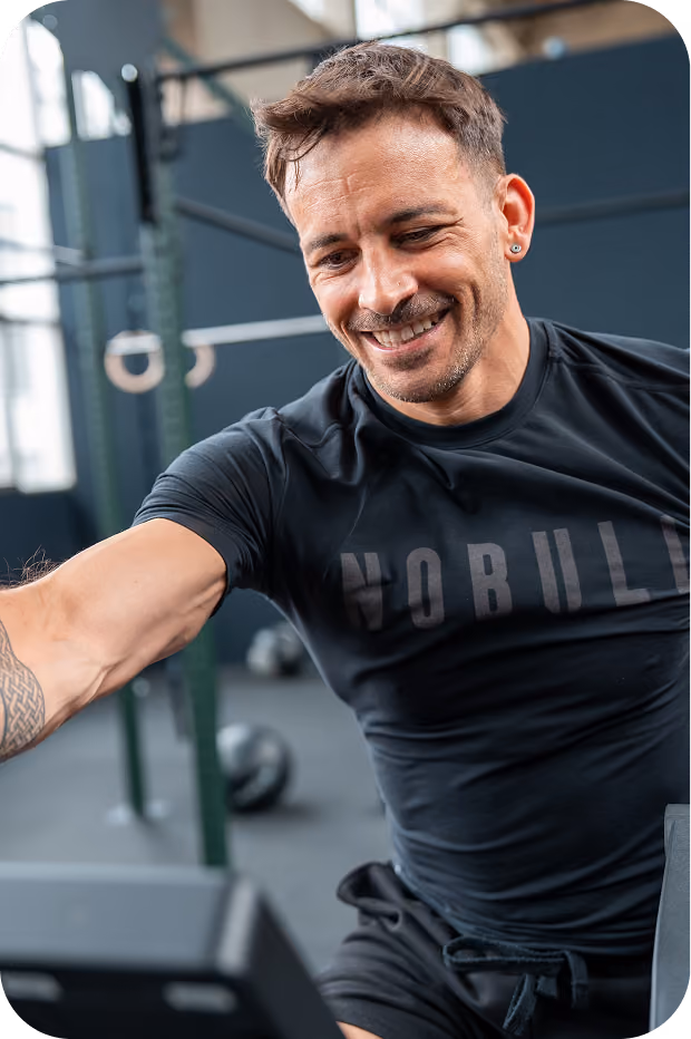 Lächelnder Mann beim Training auf dem Rudergerät