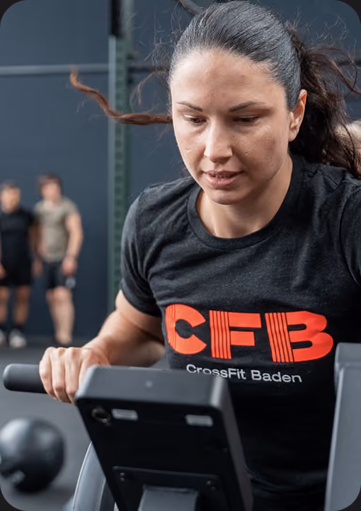 Frau beim intensiven Training auf dem Rudergerät