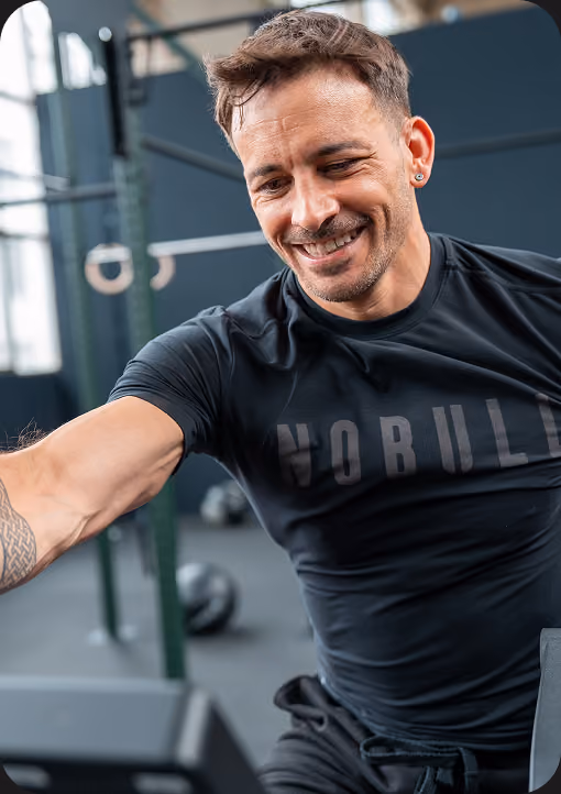 Lächelnder Mann beim Training auf dem Rudergerät
