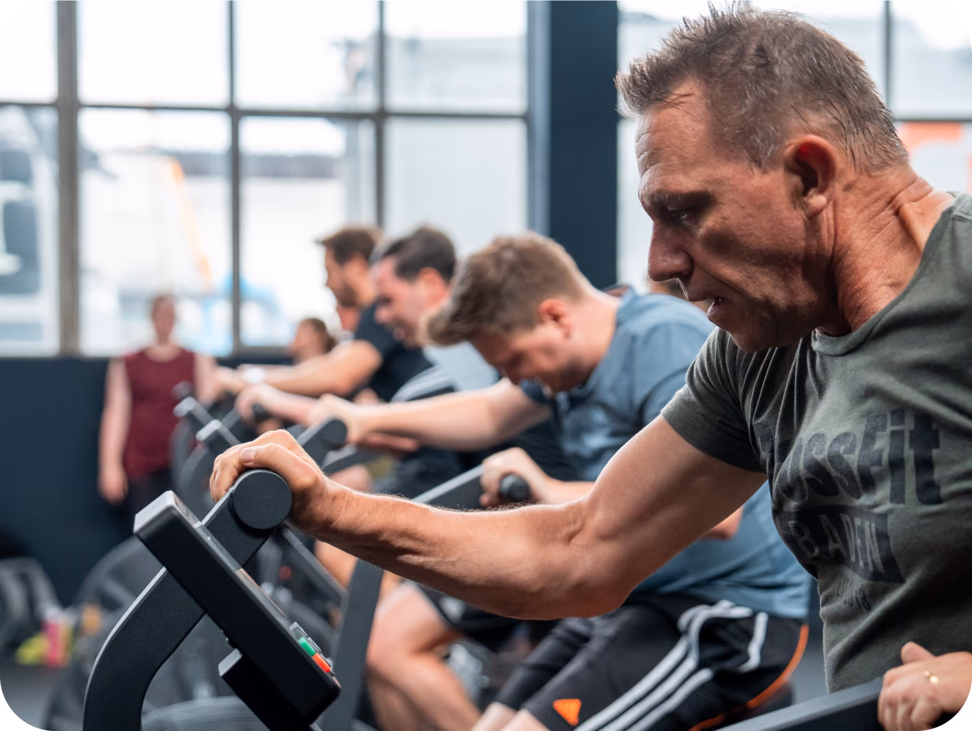 Gruppe beim gemeinsamen Training auf Rudergeräten