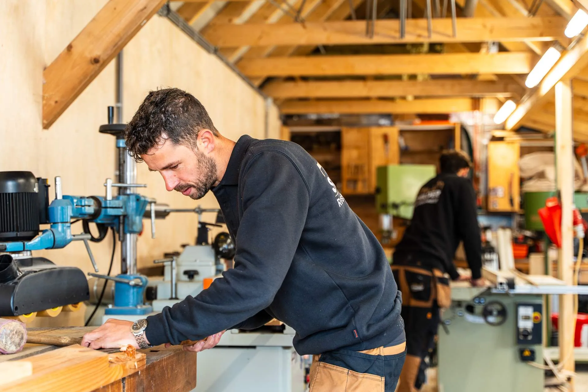 Vakman bewerkt een houten balk in de machinale timmerwerkplaats in IJsselmuiden