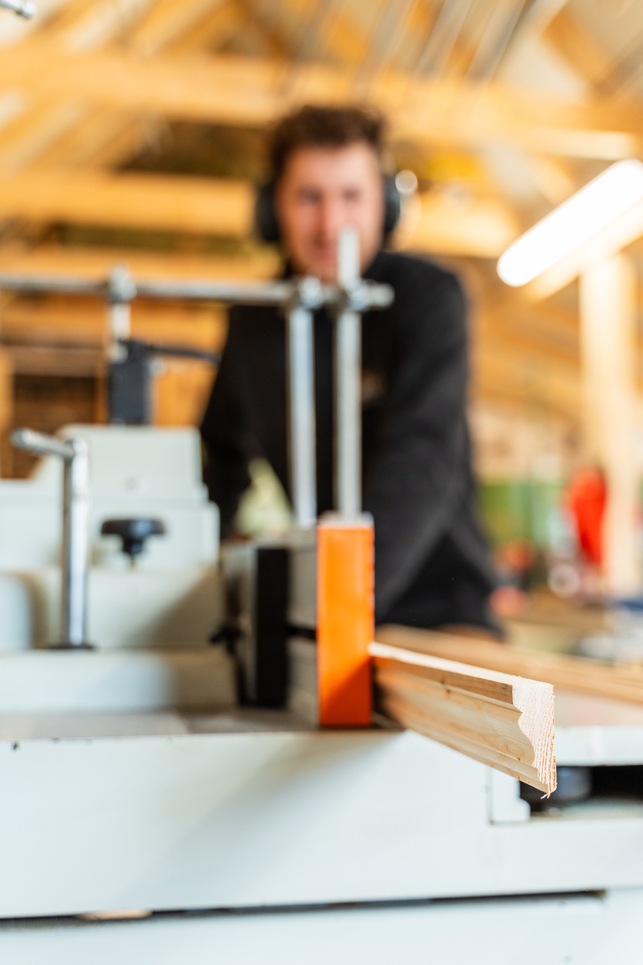 Geprofileerde houten lijst komt uit de freesmachine in de timmerwerkplaats