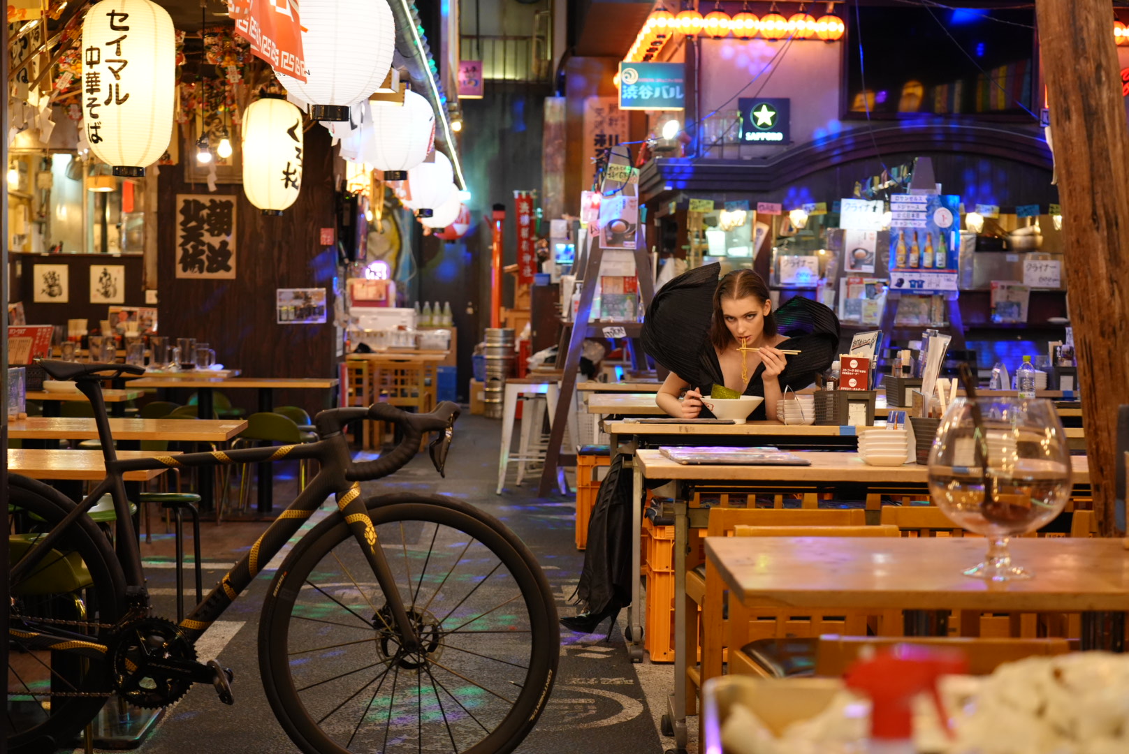 A SWI parked on a Tokyo street at night, outside a lantern-lit bar