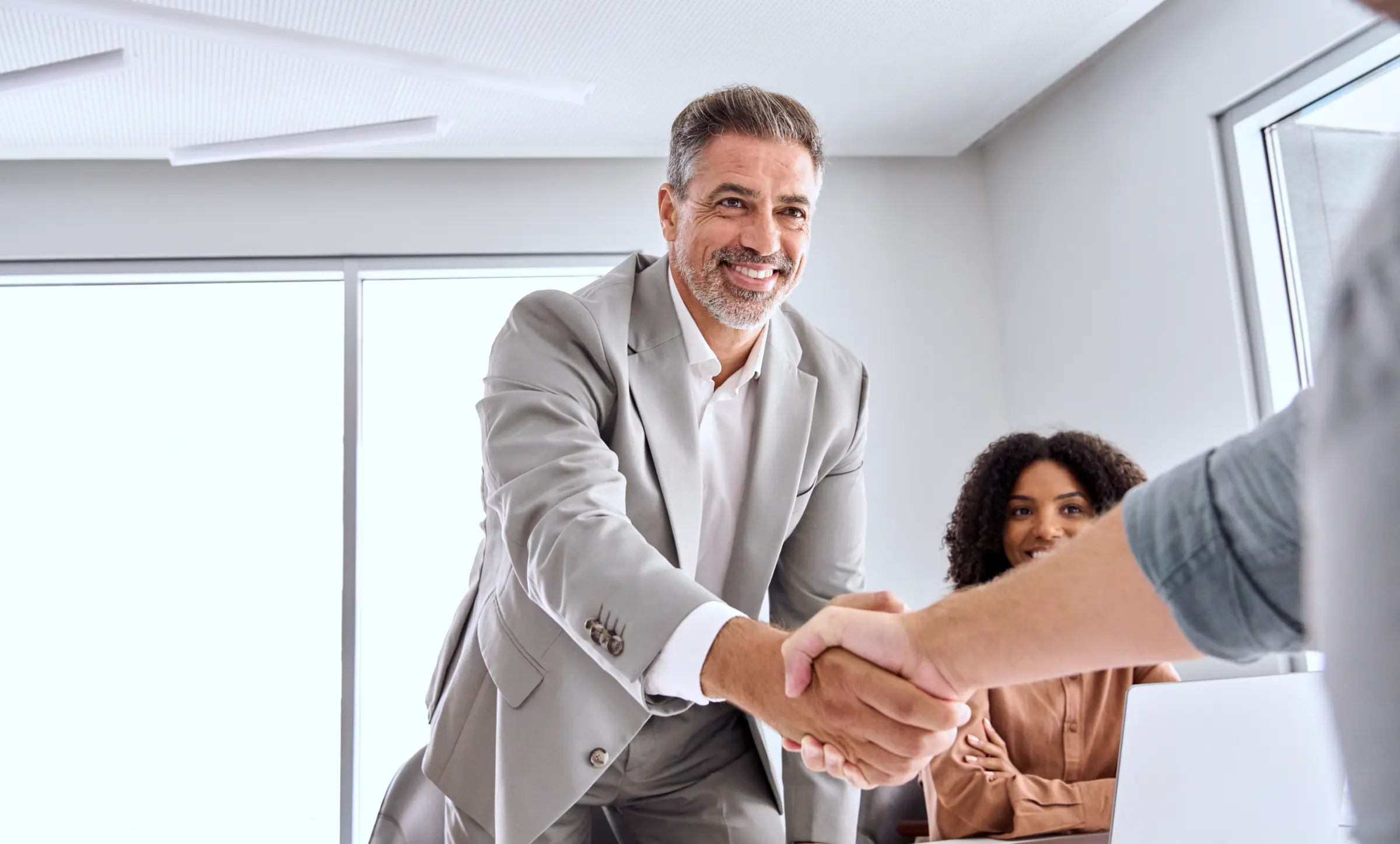 Happy business leader shaking hands with new client