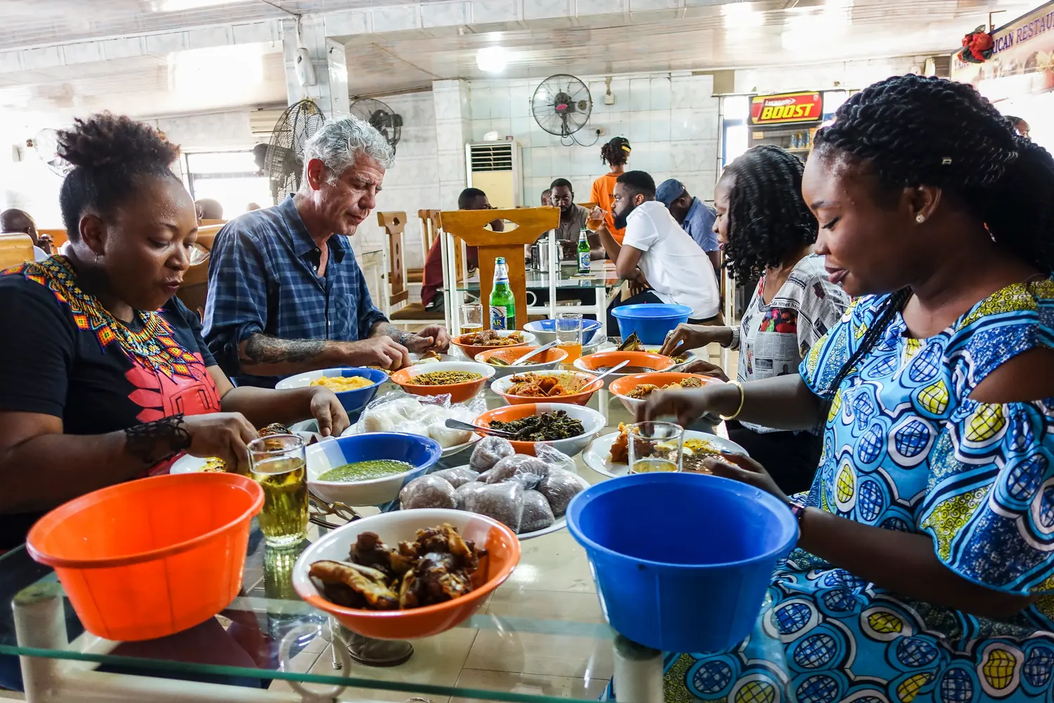 Anthony Bourdain shares a meal with three women at a restaurant in Lagos.