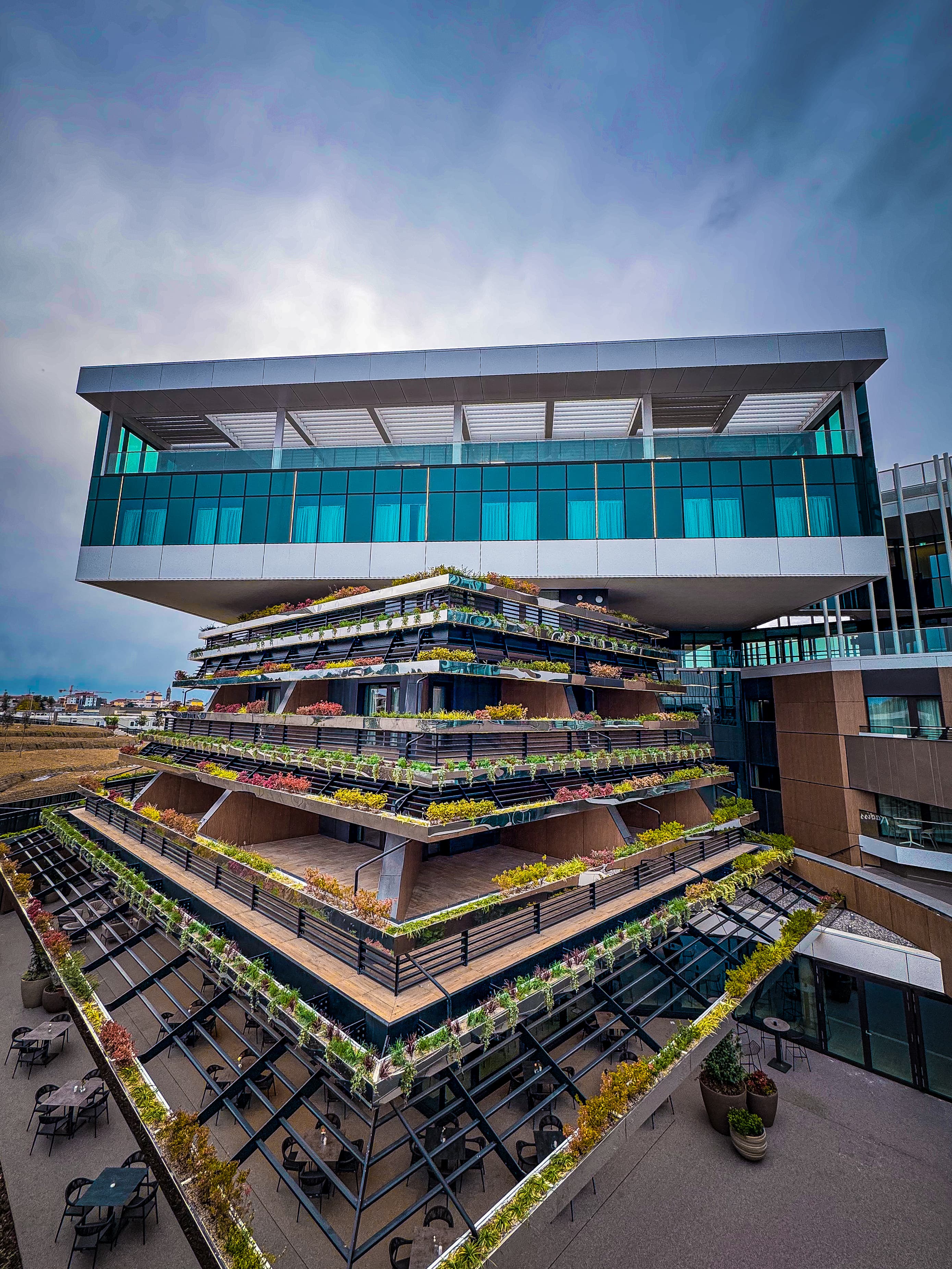 The hotel's glazed volume above the green terraces