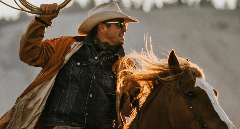 Cowboy roping on horseback at golden hour