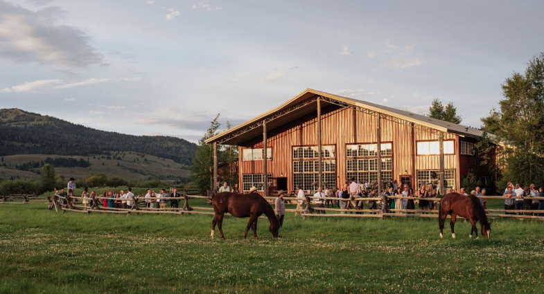 Ranch barn venue with horses grazing in the pasture
