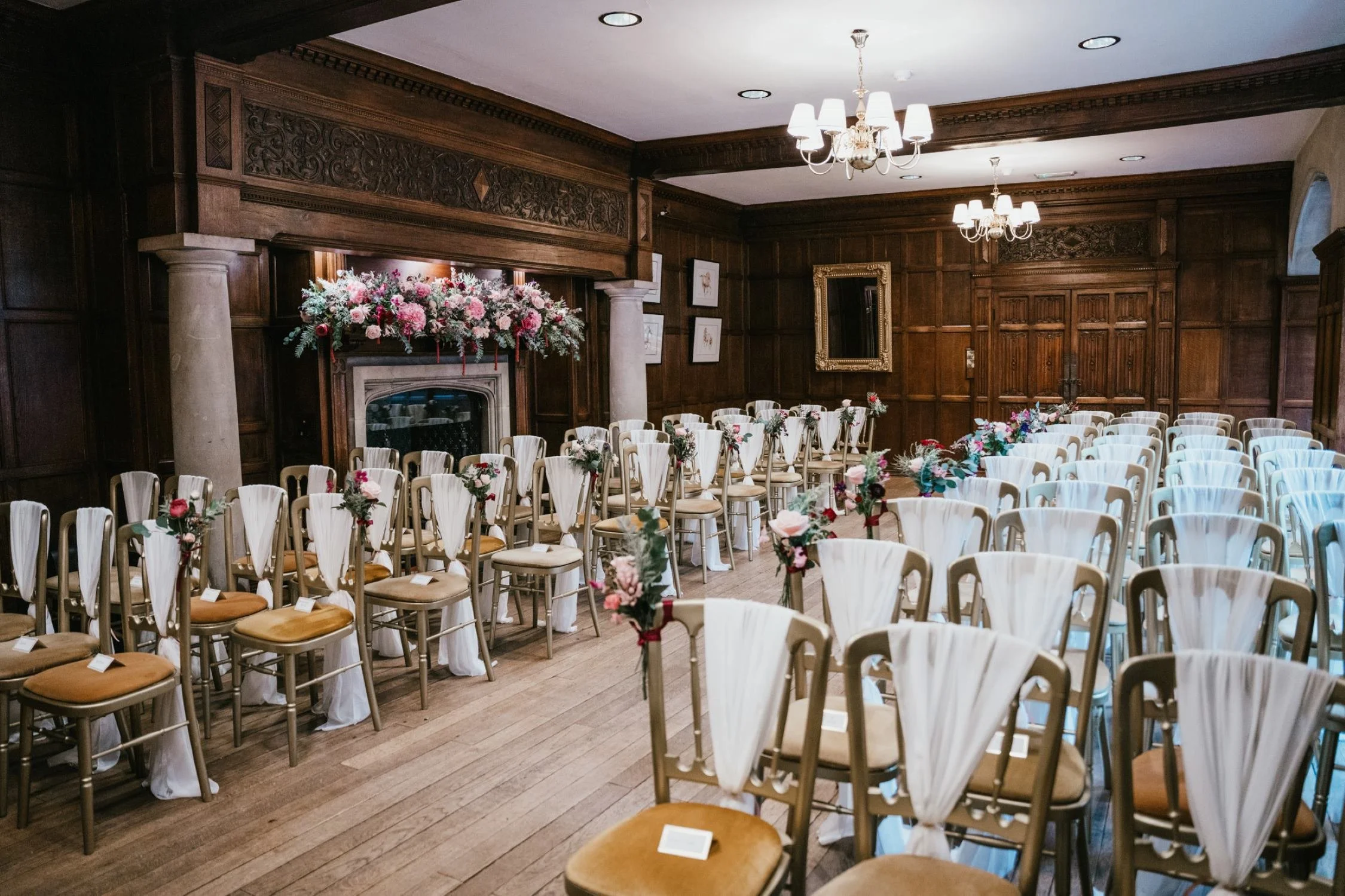 A wood-panelled ceremony room with flowers at Lanwades Hall