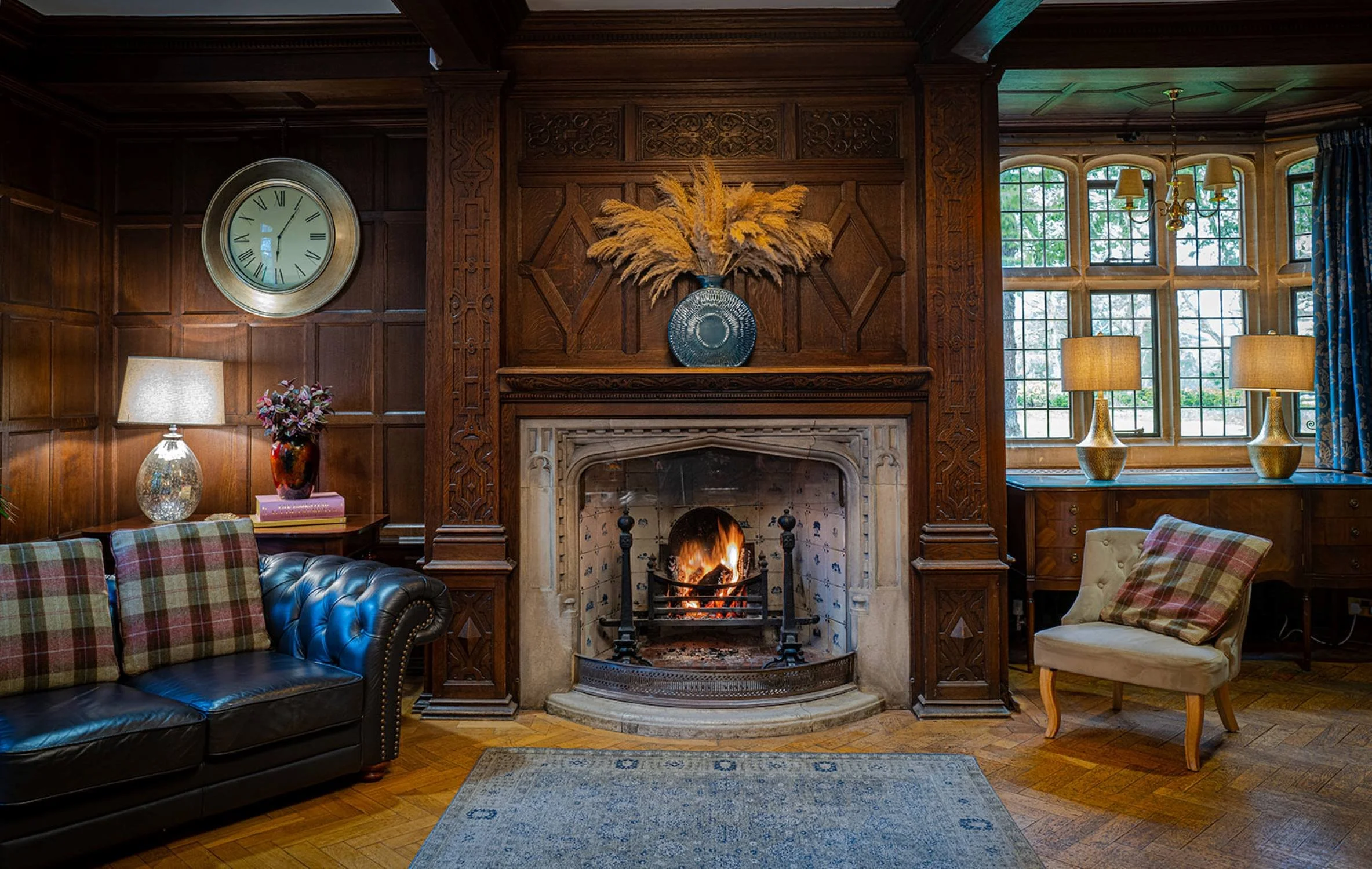 The Drawing Room at Lanwades Hall, with oak panelling and an open fire