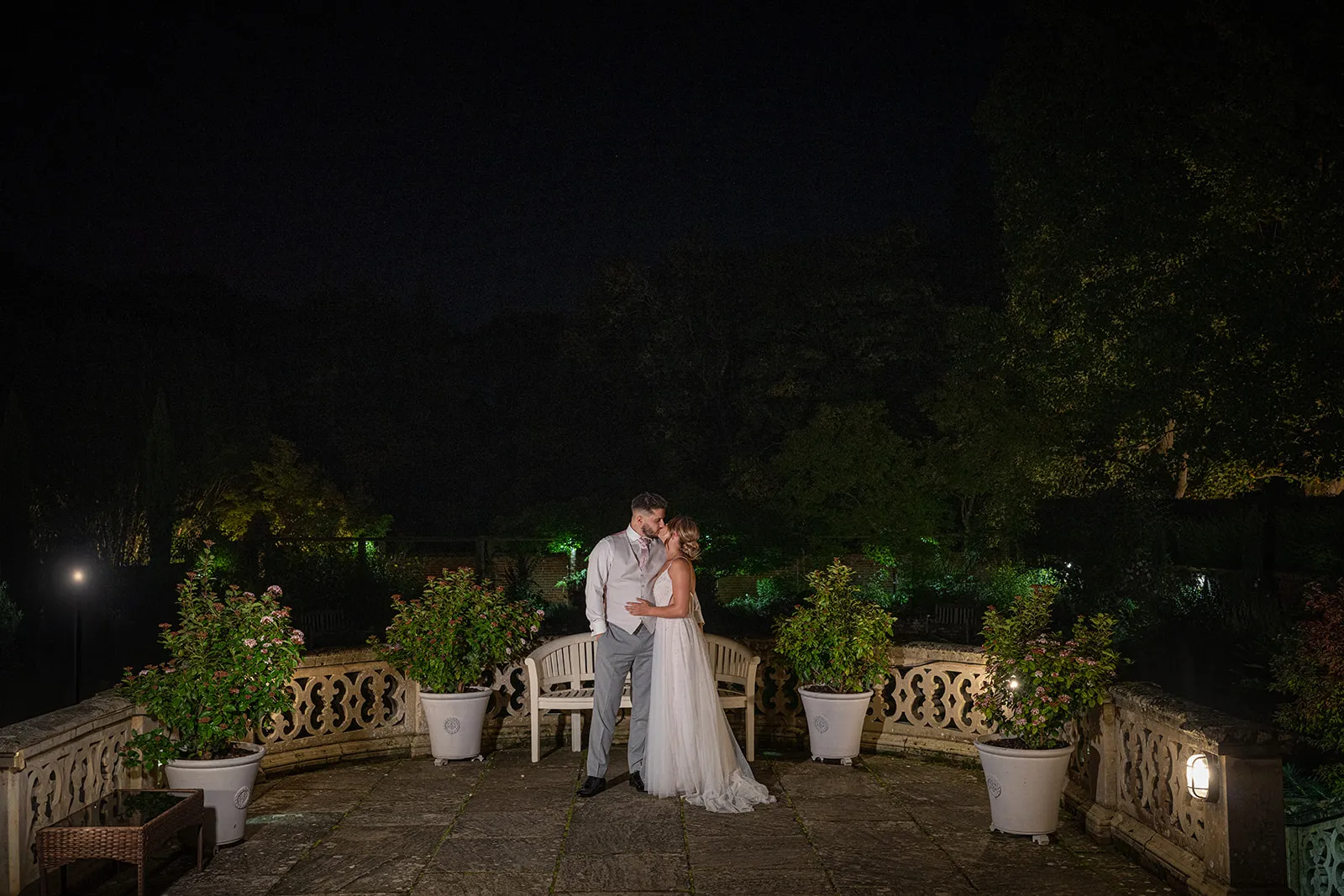 A bride and groom on the balustraded terrace on the wedding night at Lanwades Hall