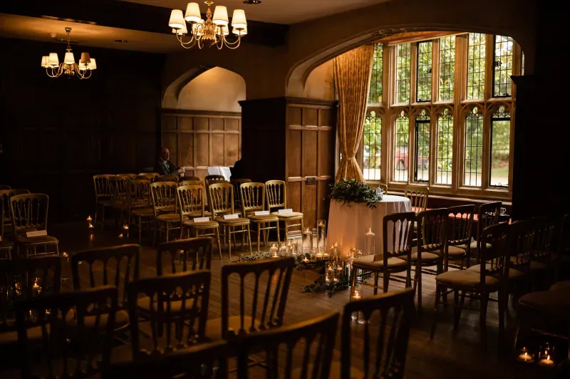 The oak-panelled hall at Lanwades Hall set with candles for a wedding ceremony