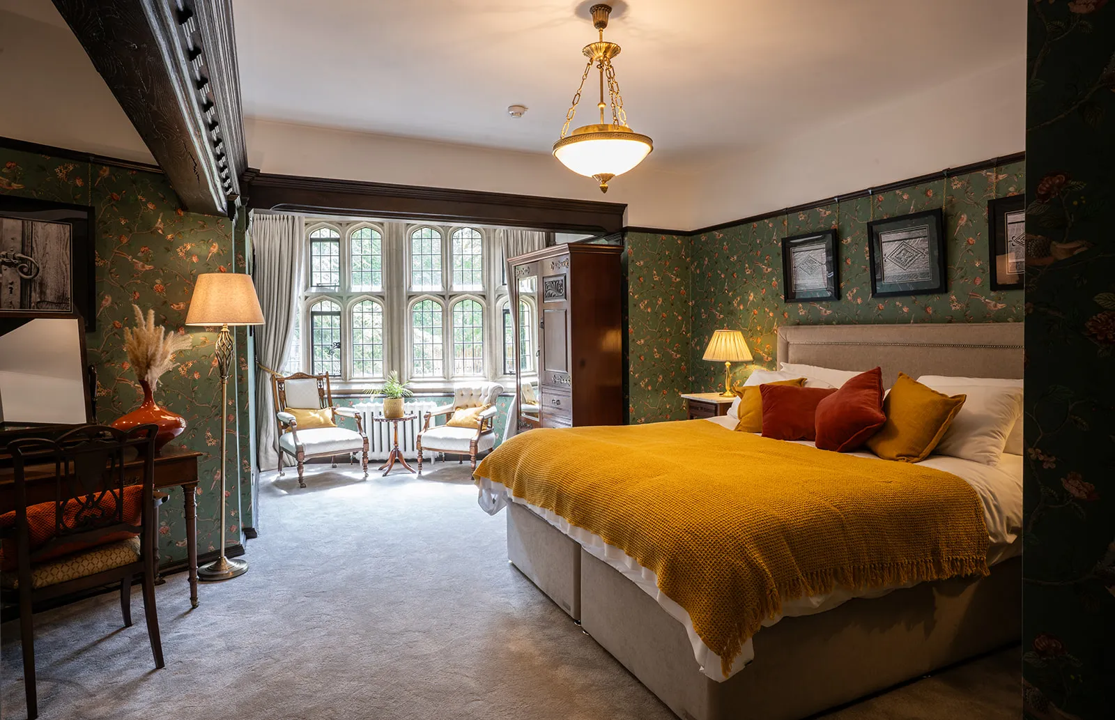 A double bedroom with green botanical wallpaper at Lanwades Hall