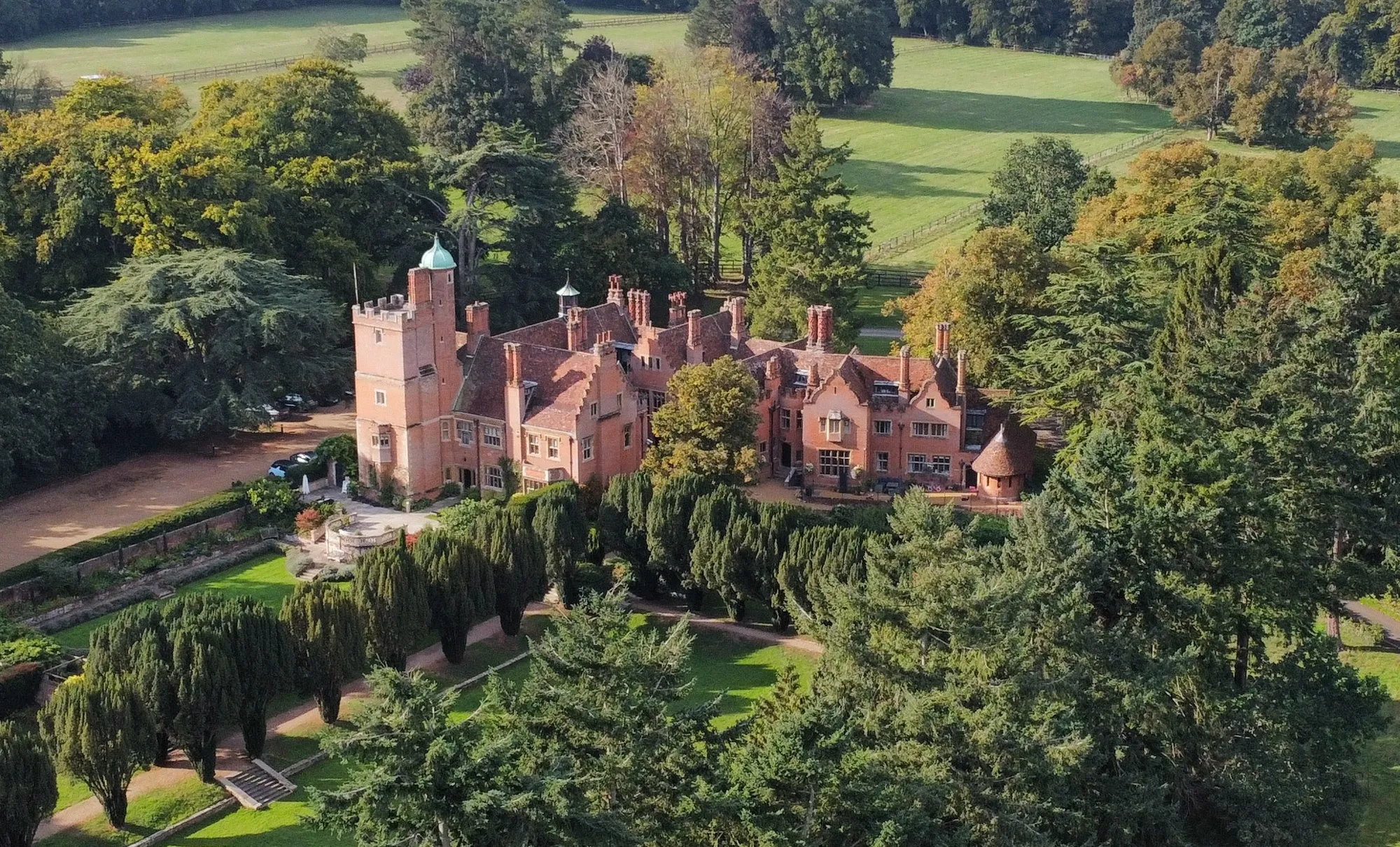 Aerial view of Lanwades Hall and its yew gardens and parkland in autumn