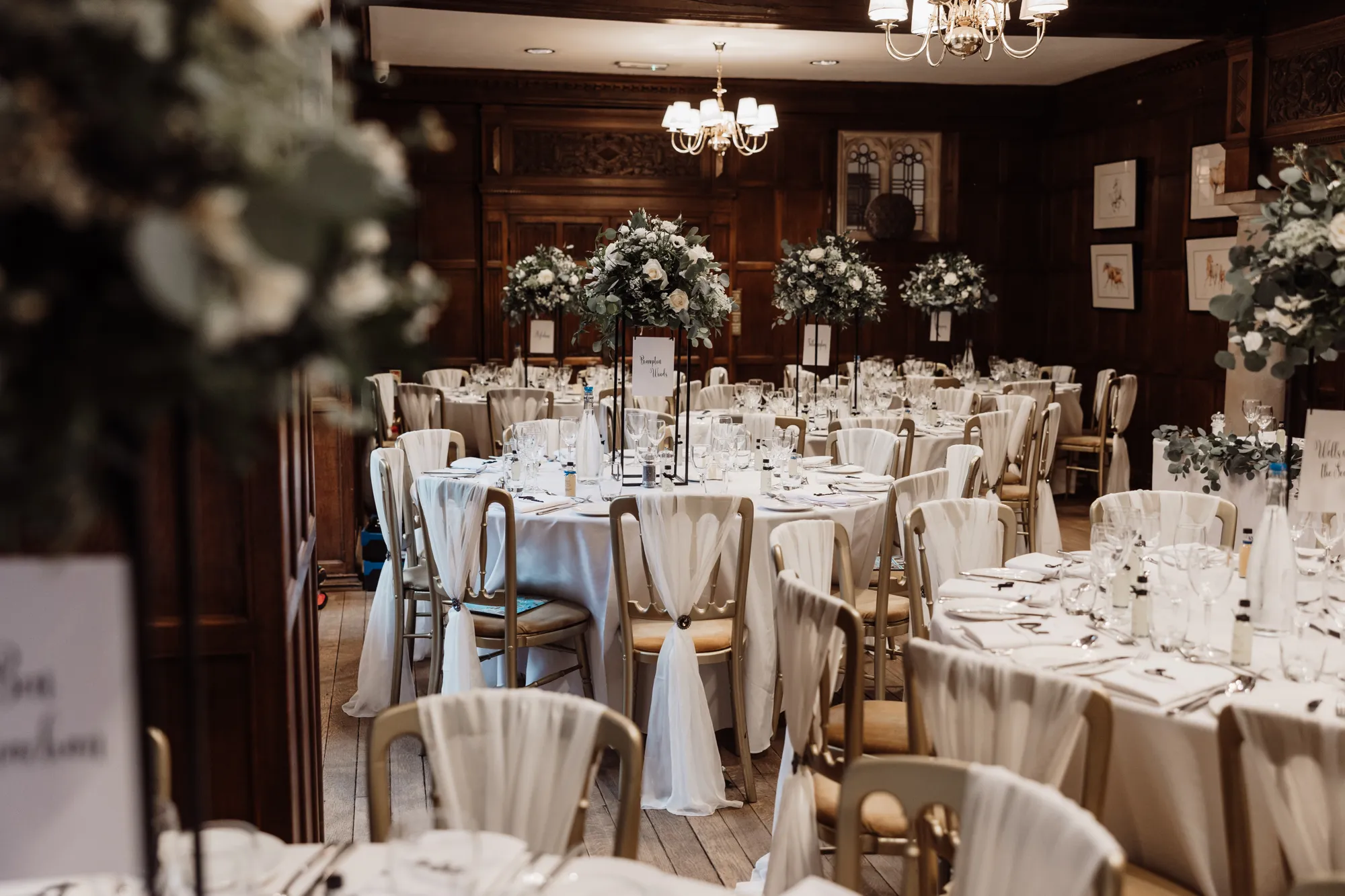 Round tables dressed for a wedding breakfast in the Great Hall at Lanwades Hall