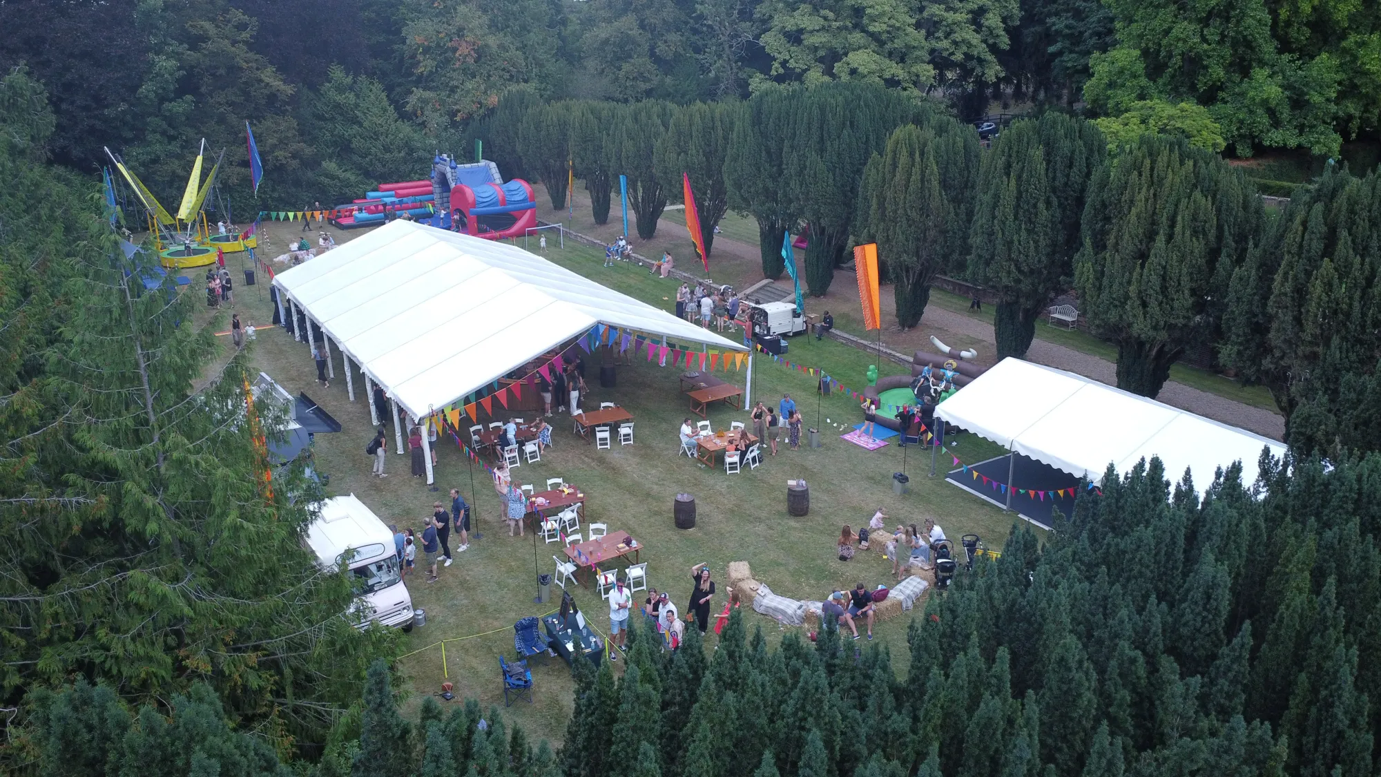 Aerial view of a summer party with marquees and bunting in the grounds of Lanwades Hall