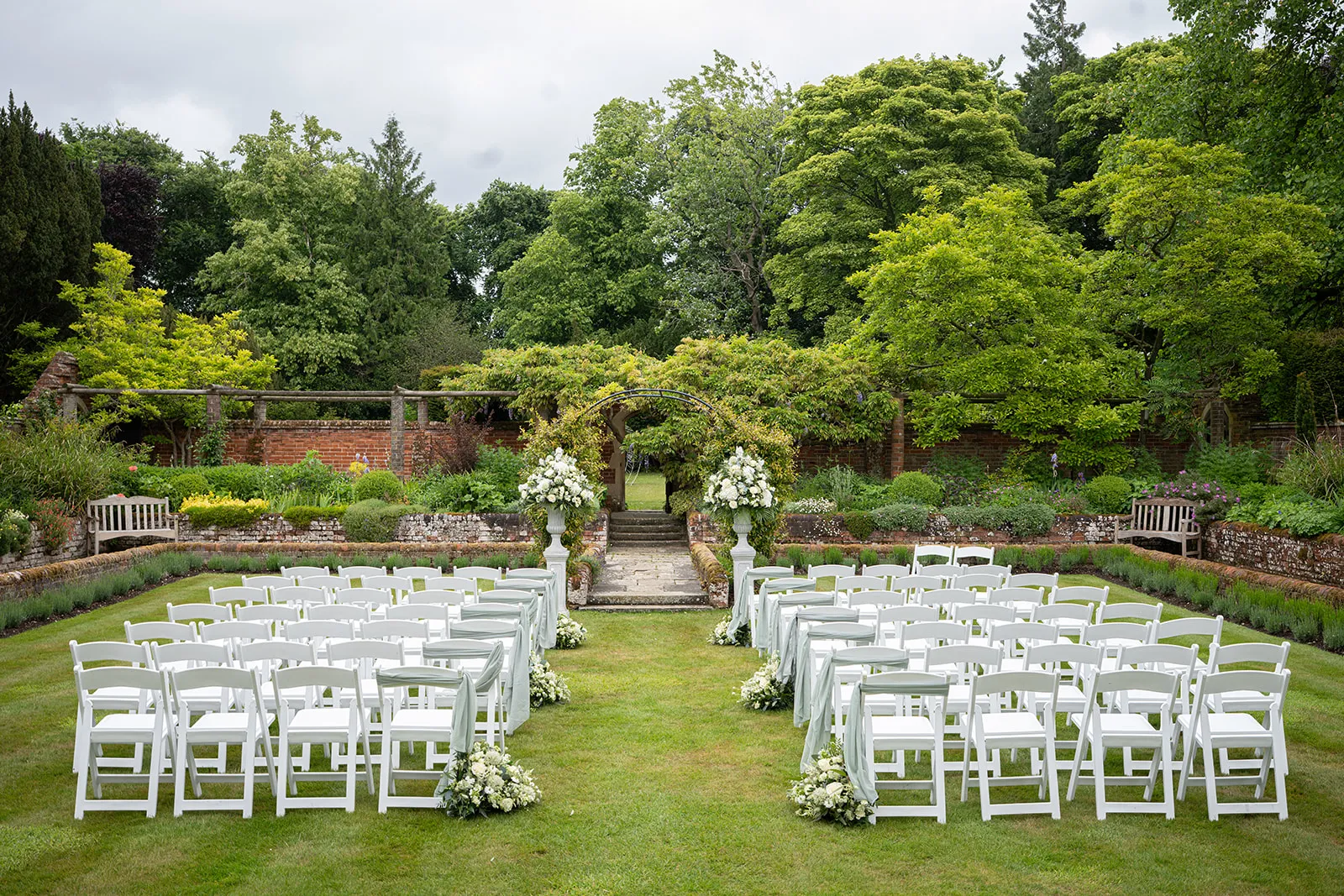 Chairs set for an outdoor wedding ceremony in the sunken garden at Lanwades Hall