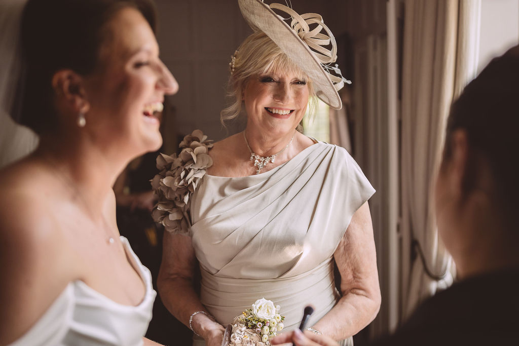 A bride and her mother laughing together during a wedding at Lanwades Hall